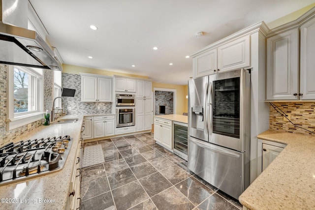 kitchen with wine cooler, decorative backsplash, recessed lighting, stainless steel appliances, and a sink