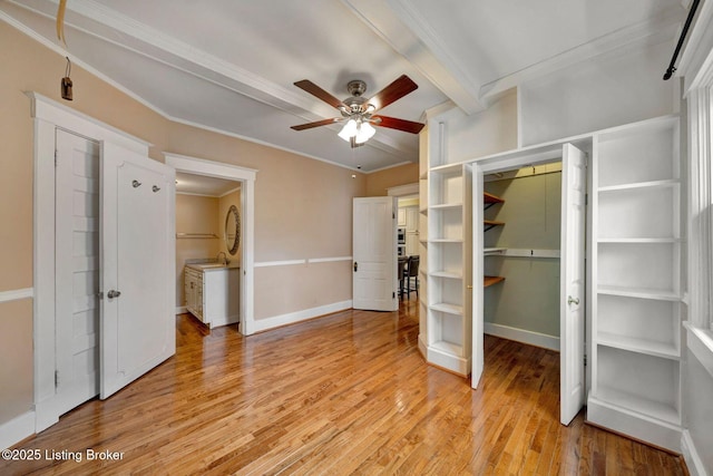 unfurnished bedroom with baseboards, light wood finished floors, a sink, a closet, and crown molding