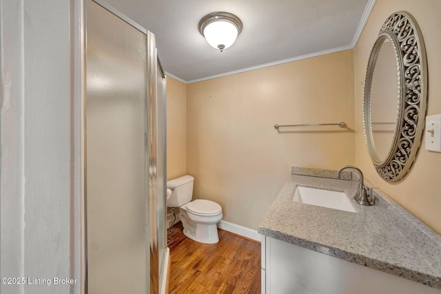 bathroom with toilet, a stall shower, wood finished floors, and ornamental molding