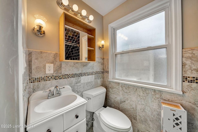 bathroom featuring vanity, tile walls, and toilet