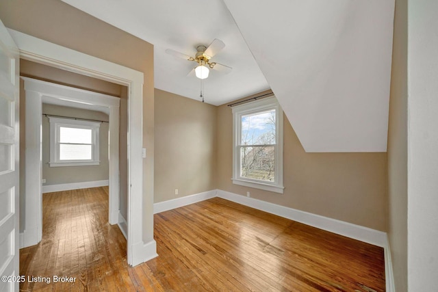 bonus room featuring a wealth of natural light, vaulted ceiling, baseboards, and hardwood / wood-style flooring