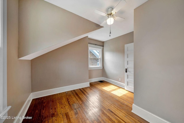 additional living space featuring ceiling fan, baseboards, and hardwood / wood-style floors