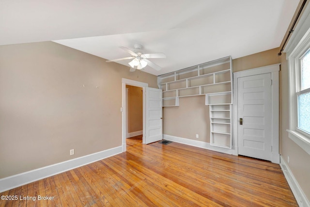 unfurnished bedroom featuring light wood-type flooring, visible vents, a ceiling fan, a closet, and baseboards