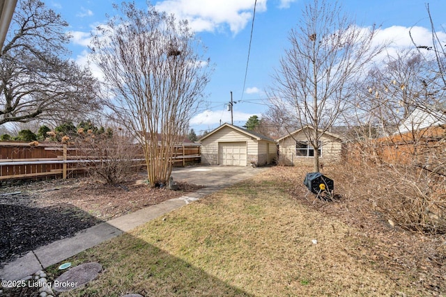 view of front of property with a front lawn, fence, concrete driveway, an outdoor structure, and a garage