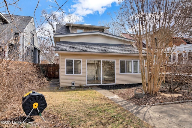 back of house featuring a lawn and fence