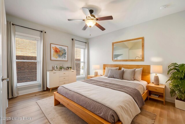 bedroom featuring light wood-style floors, baseboards, and ceiling fan