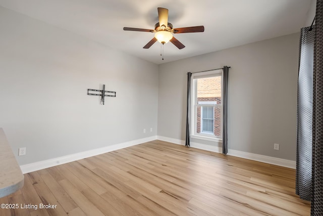 unfurnished room featuring ceiling fan, light wood-type flooring, and baseboards