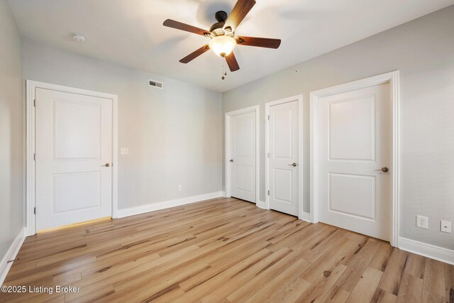 unfurnished bedroom with visible vents, light wood-type flooring, and baseboards