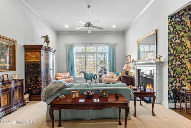 carpeted living area featuring plenty of natural light, a lit fireplace, and ornamental molding