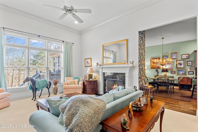 living room with recessed lighting, a warm lit fireplace, and a ceiling fan