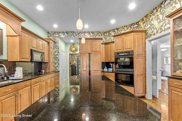 kitchen with wallpapered walls, decorative light fixtures, recessed lighting, black appliances, and a sink