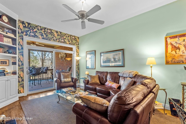 living area with a ceiling fan, wood finished floors, and baseboards