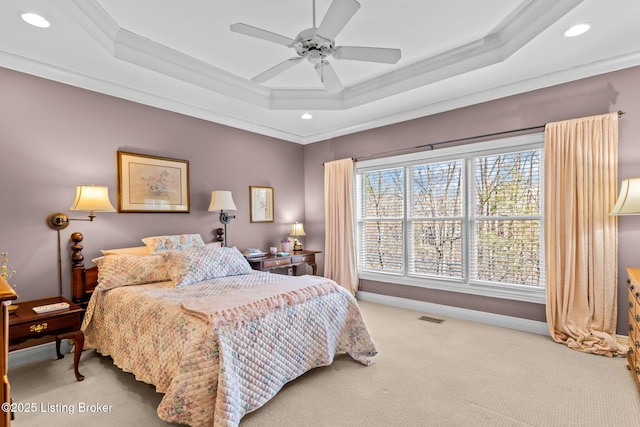 carpeted bedroom with a raised ceiling, baseboards, and visible vents