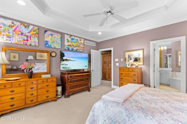 carpeted bedroom with a tray ceiling, visible vents, ornamental molding, and ensuite bathroom