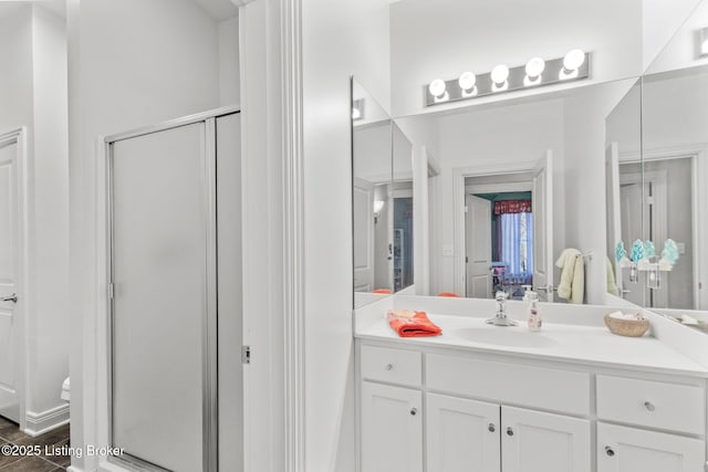 full bathroom featuring wood finished floors, toilet, a stall shower, and vanity