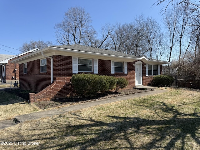 view of front facade with brick siding and a front lawn