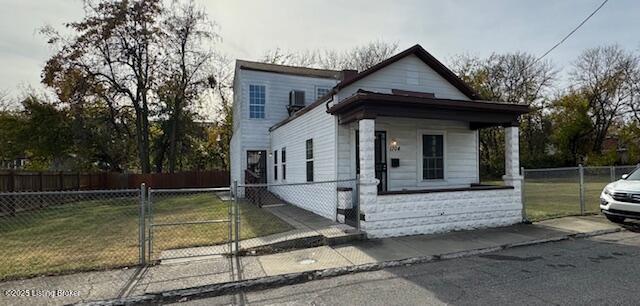 shotgun-style home with a front yard, a gate, and a fenced front yard