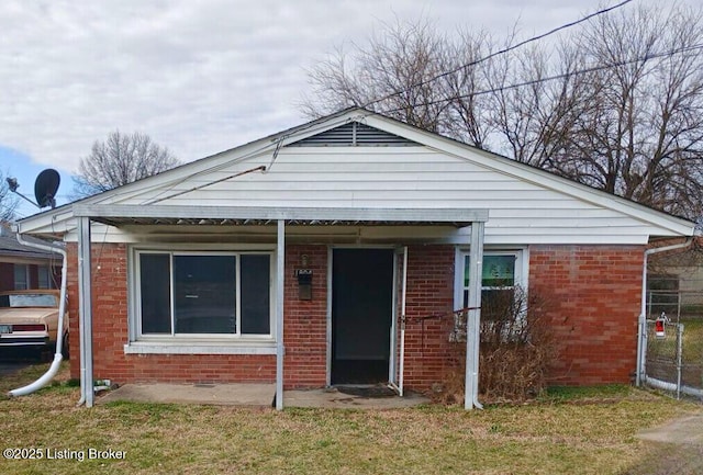 bungalow-style house with a front lawn and brick siding