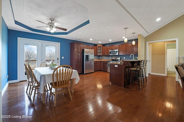 dining space featuring a textured ceiling, baseboards, and dark wood-style flooring