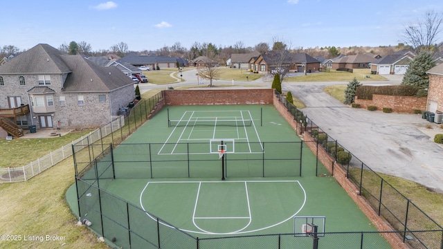 exterior space featuring a residential view, a lawn, community basketball court, and fence