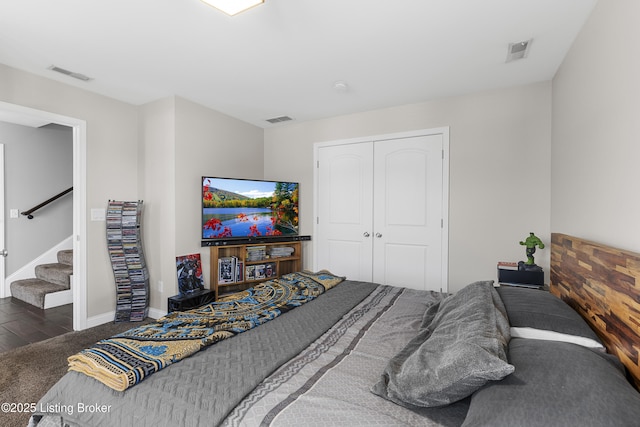 bedroom featuring dark wood-type flooring, visible vents, and a closet