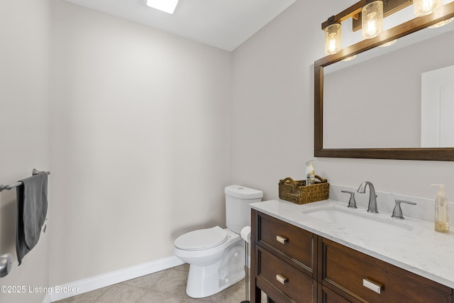 half bathroom featuring baseboards, toilet, vanity, and tile patterned flooring