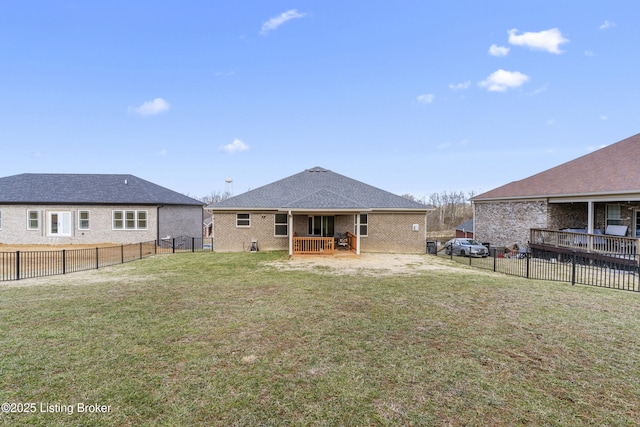 back of house featuring brick siding, a lawn, and a fenced backyard