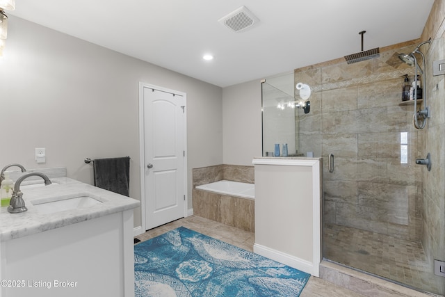 bathroom featuring visible vents, a shower stall, double vanity, a bath, and a sink