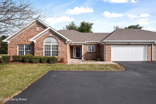 single story home featuring brick siding, a shingled roof, aphalt driveway, a front yard, and a garage