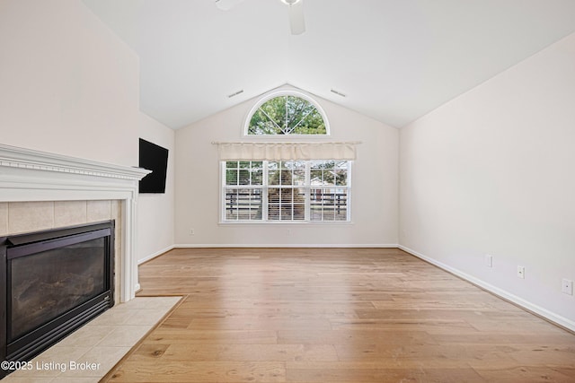 unfurnished living room with visible vents, light wood-style flooring, a fireplace, ceiling fan, and vaulted ceiling