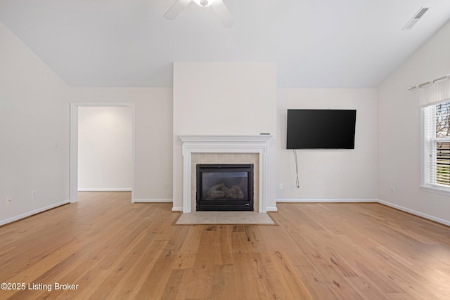 unfurnished living room featuring visible vents, ceiling fan, light wood-type flooring, vaulted ceiling, and a fireplace