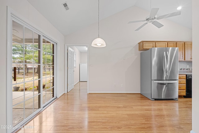 kitchen with visible vents, light wood-type flooring, freestanding refrigerator, and black dishwasher