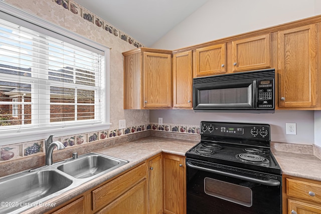 kitchen featuring black appliances, light countertops, lofted ceiling, and a sink