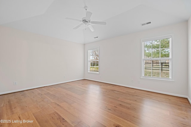 empty room featuring visible vents, baseboards, lofted ceiling, light wood-style flooring, and ceiling fan