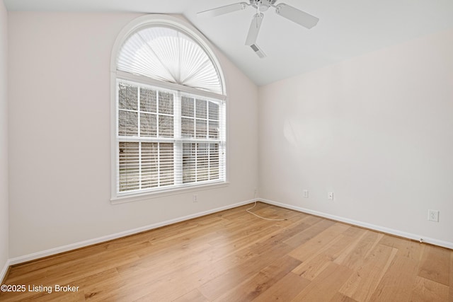 unfurnished room featuring a wealth of natural light, visible vents, a ceiling fan, and wood finished floors