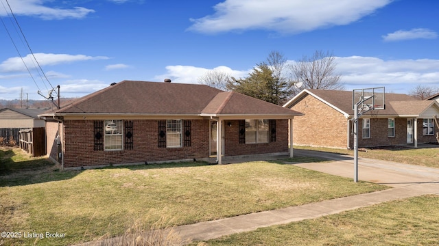 view of front of property featuring brick siding, fence, a front yard, and roof with shingles