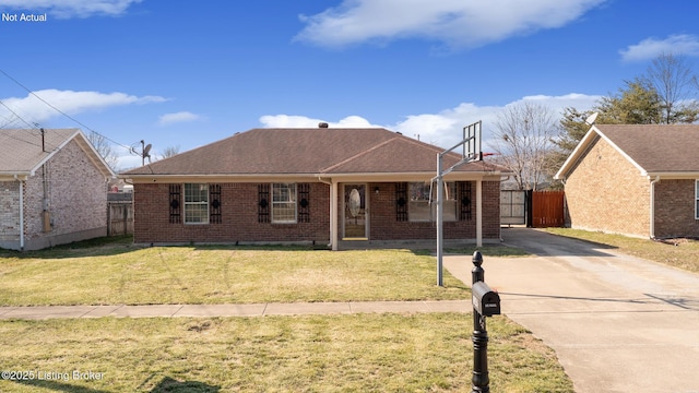 view of front facade with a front lawn, fence, and brick siding