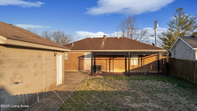 back of property with brick siding and fence