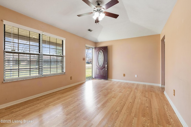 entrance foyer with a ceiling fan, vaulted ceiling, light wood-style floors, and baseboards