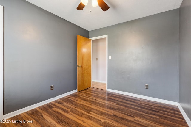 unfurnished room with dark wood-style floors, baseboards, and ceiling fan