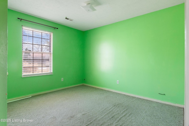 carpeted spare room featuring visible vents, baseboards, and a textured ceiling