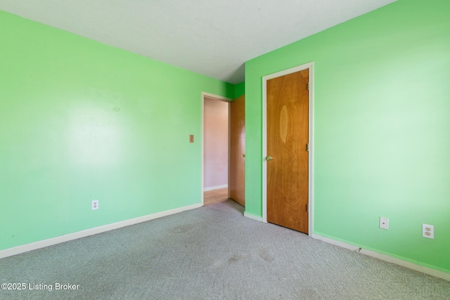 carpeted spare room with baseboards