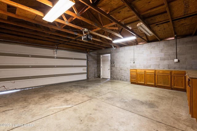 garage with concrete block wall and a garage door opener