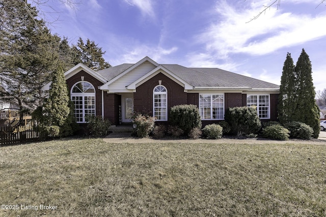 ranch-style house with brick siding, a front lawn, and fence