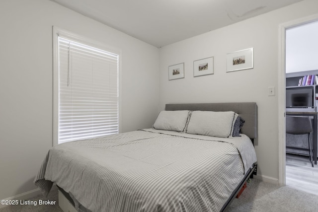 carpeted bedroom with multiple windows and baseboards