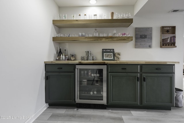 bar featuring a dry bar, beverage cooler, visible vents, and baseboards