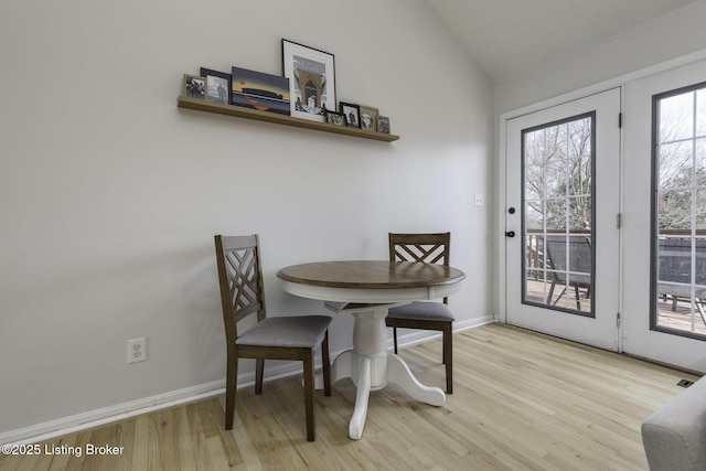 dining area with lofted ceiling, wood finished floors, and baseboards