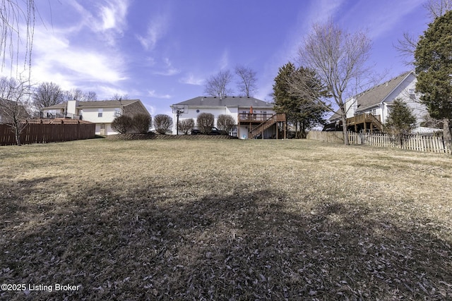 view of yard featuring a wooden deck, fence private yard, and stairs