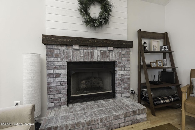 interior details featuring a brick fireplace and wood finished floors