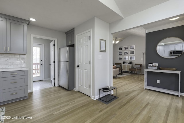 kitchen featuring light wood-type flooring, stainless steel appliances, gray cabinetry, and ceiling fan